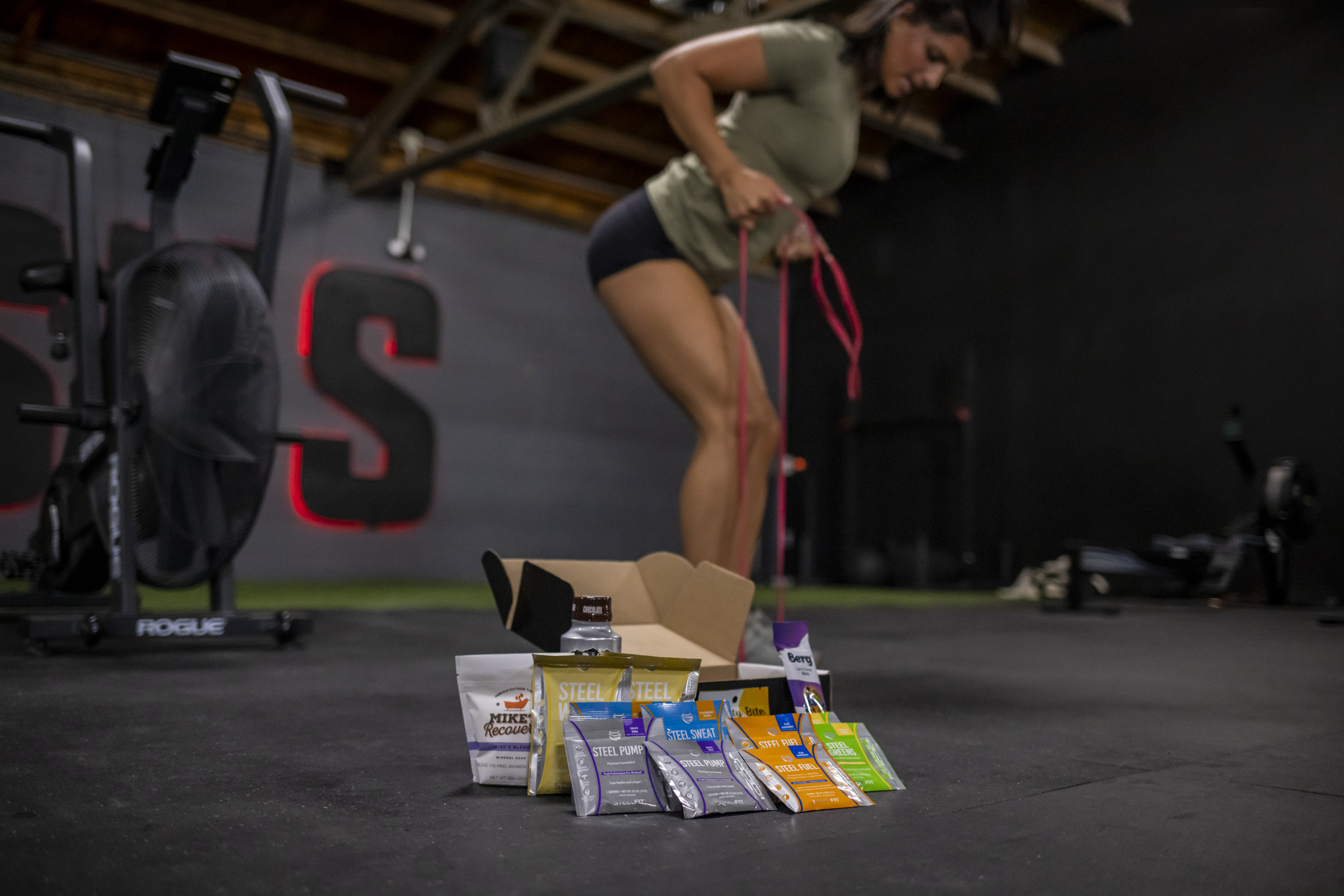 Contents of The Lift Box displayed with woman working out in background.