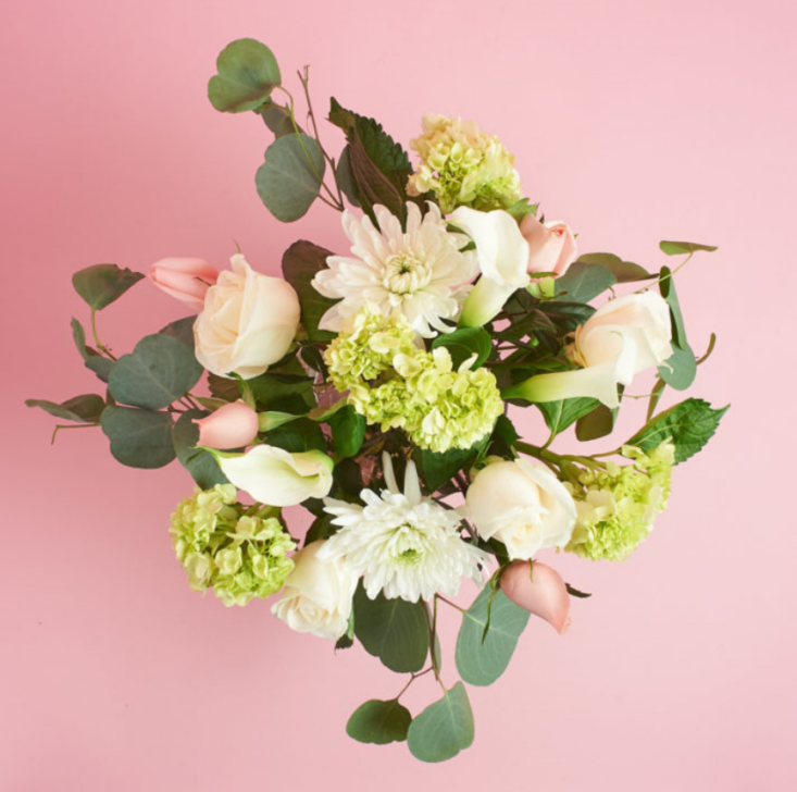 The Deluxe Poetic Bouquet features roses, hydrangea, and eucalyptus.